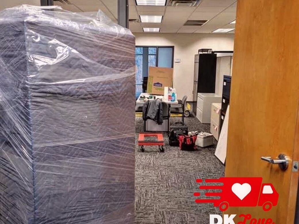 A shrink-wrapped filing cabinet staged in a doorway during a DK Love Movers office relocation